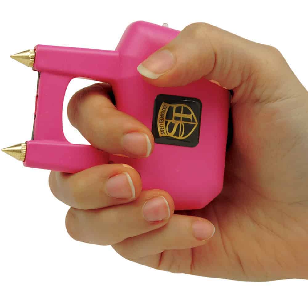 ST-SPIKE-PINK_ajpg | Para Bellum Defense Hand holding a pink self-defense stun gun with gold spikes, showcasing its compact and practical design.